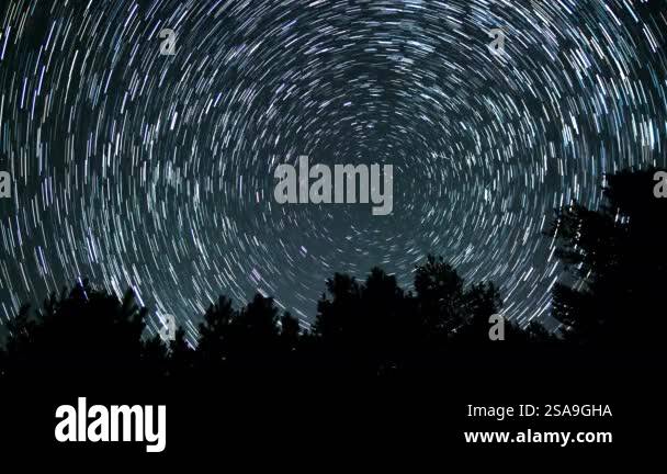 Star trails create mesmerizing patterns in the night sky above a dark ...