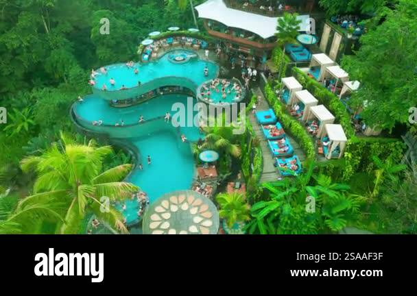 A vibrant pool area featuring multiple swimming pools, surrounded by ...