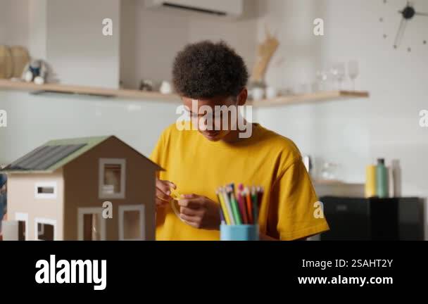 Older brother focuses on assembling small parts of model house ...