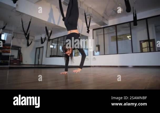 Dancer Handstand In a modern studio featuring unique equipment, an aerial dancer ...