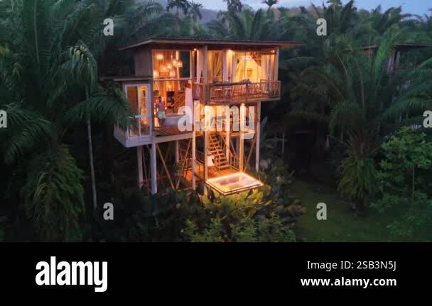 Nestled high in the trees, this enchanting retreat glows warmly as ...