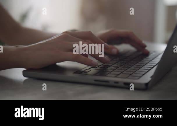 Cinematic orbiting shot of unrecognizable female hands typing on a ...