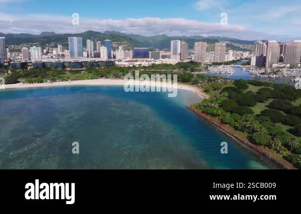 Smooth aerial pan of Honolulu's skyline with high rise buildings, lush ...