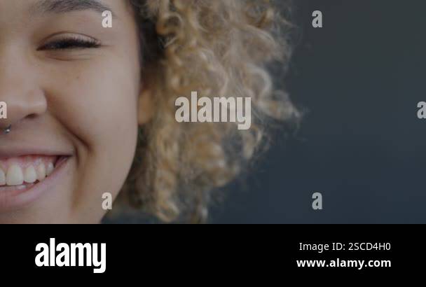 Portrait of joyful African American girl half face laughing on black ...