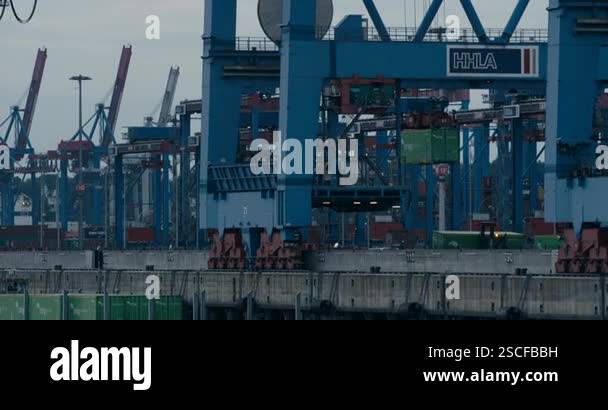 Container gantry crane lifting cargo container at port terminal Stock ...