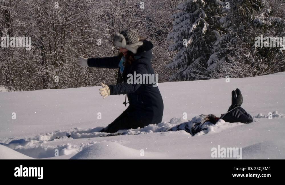 Happy young family are having fun playing in the snow. They throw snow ...