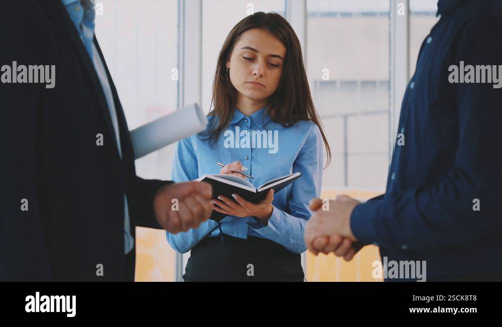 Three hilarious young business people talk to each other while ...