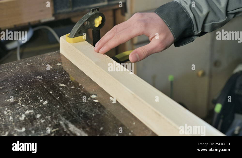 Close-up of a male carpenter's hand checking the smoothness and ...