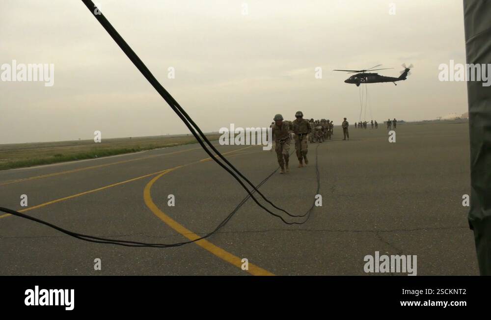 Soldiers running towards UH-60 Black Hawk for fast rope training ...