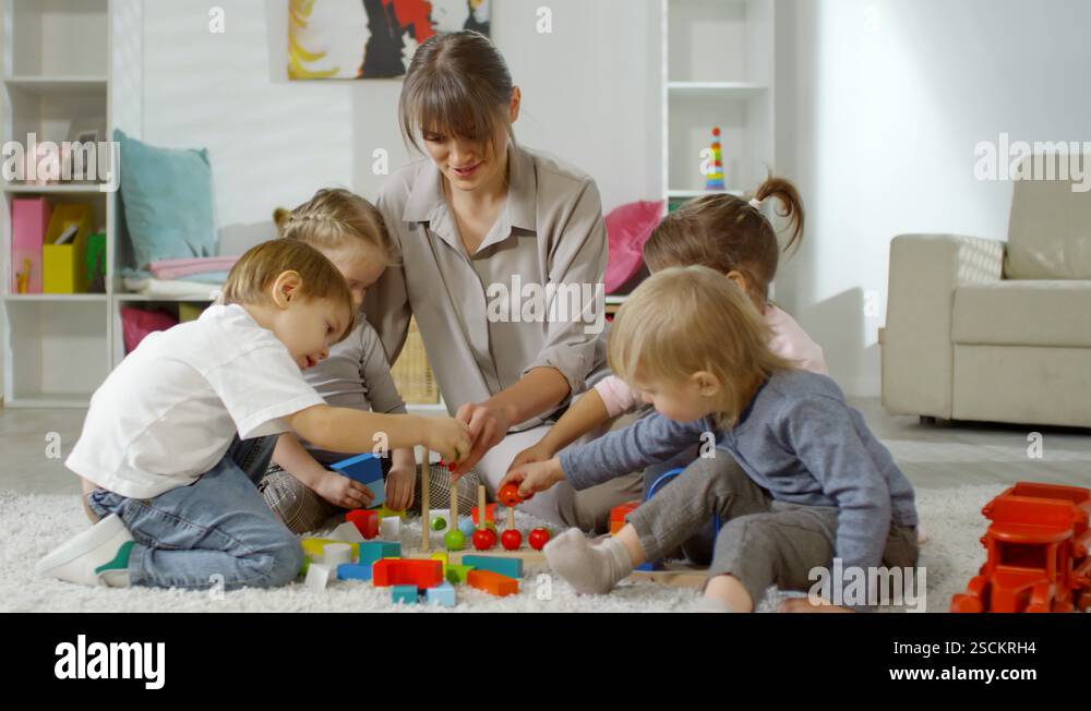 Female Teacher and Little Kids Playing Educational Toy in Daycare ...