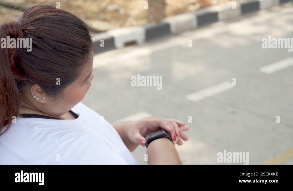 Overweight Woman Setting Smart Watch And Running Stock Video Footage