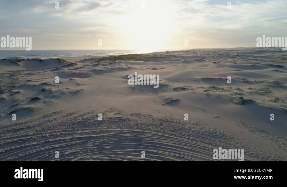 Slow rise over sand revealing ocean beach and coastline at sunrise in ...