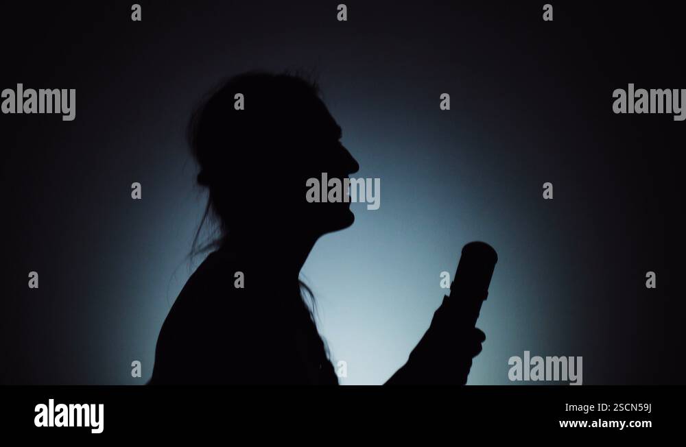 Singing Shadow Performance The shadow of a woman on a light background. The woman is singing in a ...