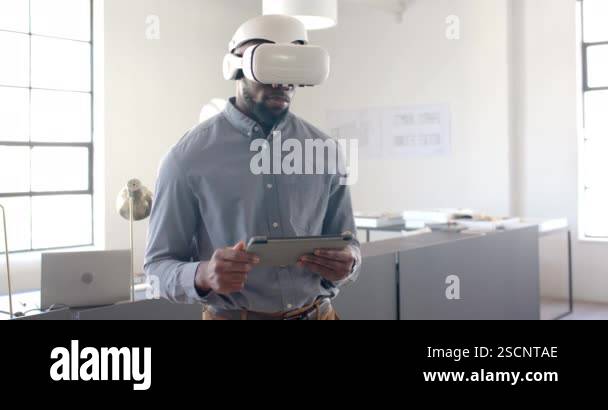 Using VR headset, businessman holding tablet in modern office ...