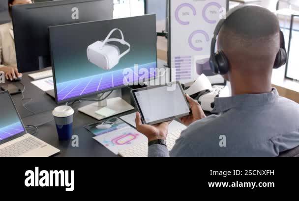 Using tablet and VR headset, African American man working on virtual ...