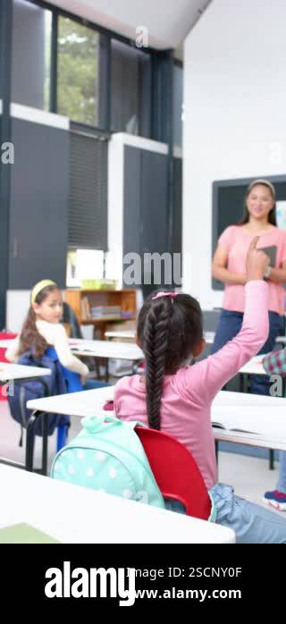 Vertical video: In school, girl raising hand to ask question while ...