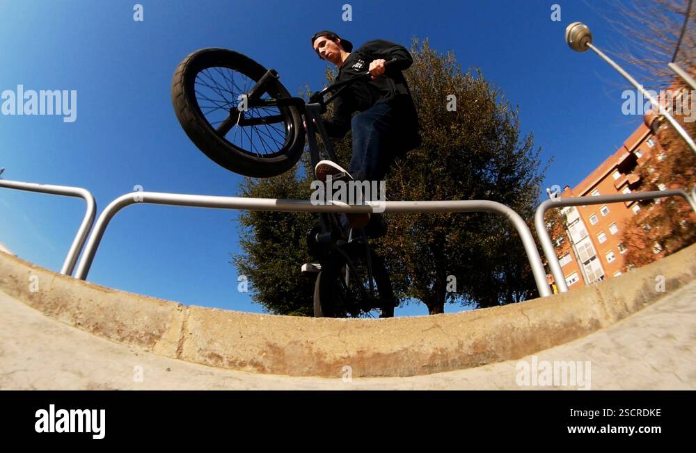 On sunny day extremal guy bmx rider practices jump tricks over ...