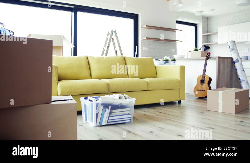 Moving boxes, ladder and clothes rack on the floor in new home Stock ...