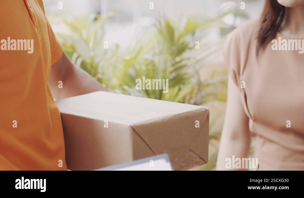 Male employee send box parcels to Asian women customers at home Stock ...