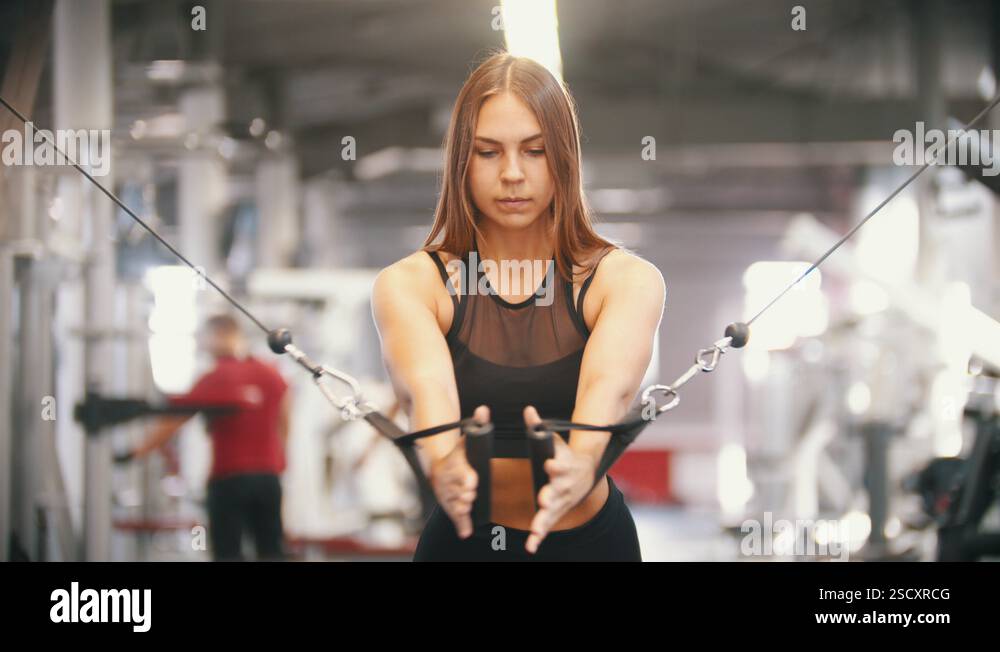Pulling Handless An athlete woman training in the gym - pulling the handles - pumping ...
