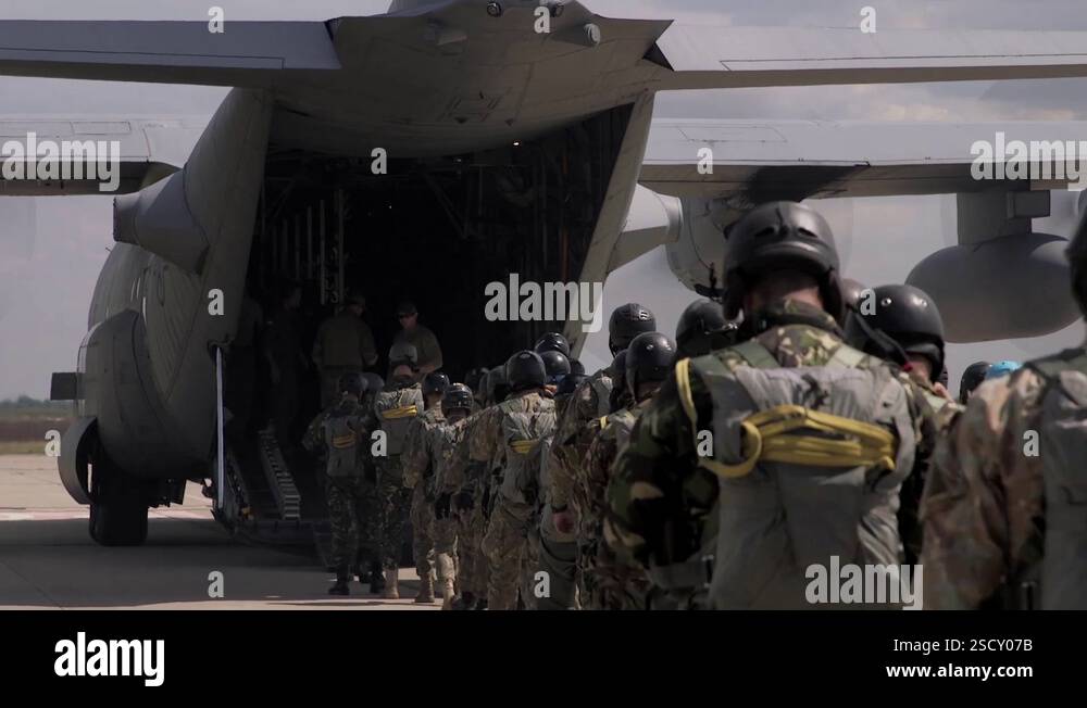 Romanian Air Force parachutists boarding C-130 Hercules via rear ramp ...