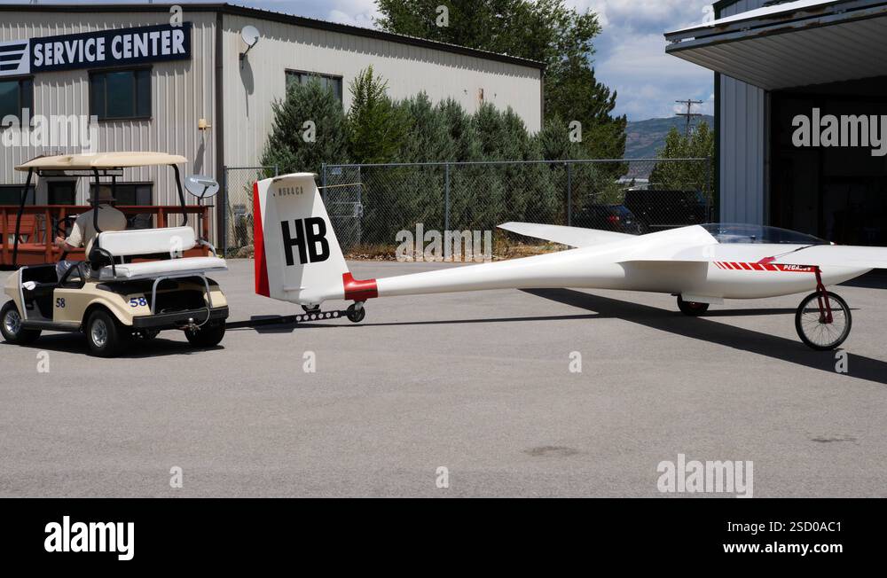 Old man is riding aerotow to the glider aircraft on the airport ramp ...