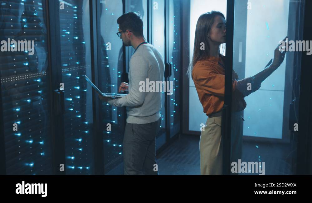 Data center female and male server engineers cooperating in working ...