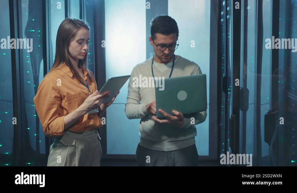 Couple of server IT engineers collaborating in data center inspecting ...
