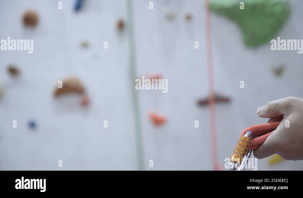 Climber in safety harness tying rope in eight knot and preparing to ...