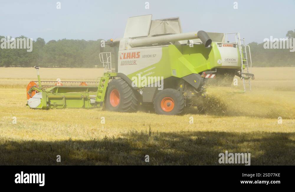 A back view of a combine harvester as it turns around and drives in a ...