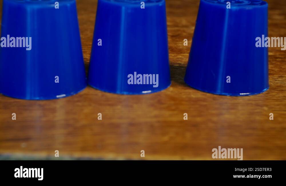 thimblerig.a hidden pea under one of the glasses moves them around the ...