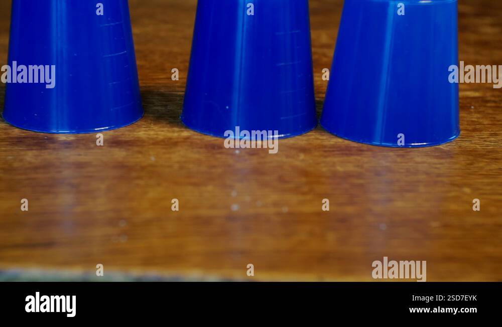 thimblerig.a hidden pea under one of the glasses moves them around the ...