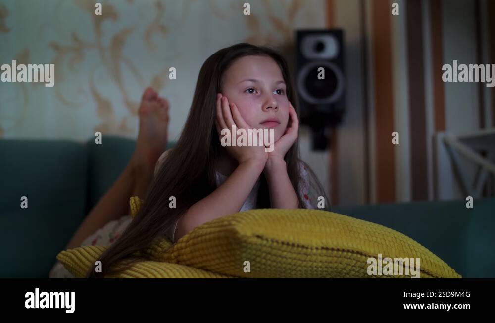 teenager-girl-in-pajamas-watching-movie-on-tv-in-darkness-lying-on-the