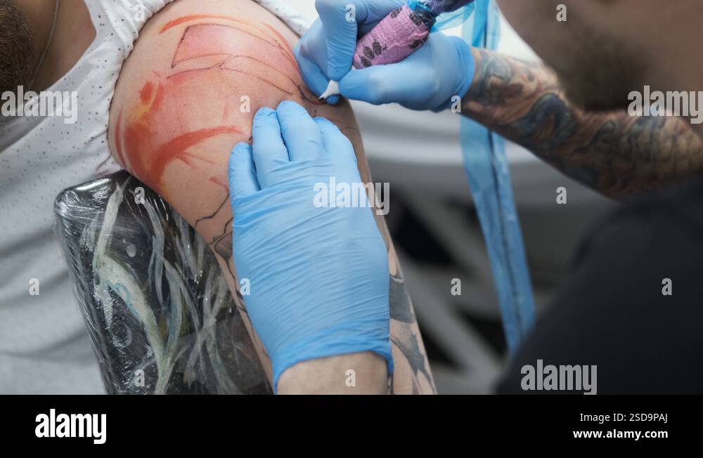 tattoo Studio, guy gets color tattoo on his arm, it's bleeding Stock ...