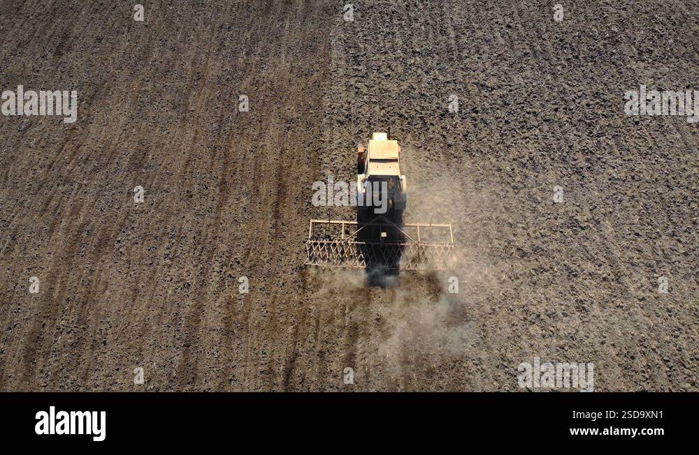 Farmer in tractor combine with cultivator preparing land for seeding ...