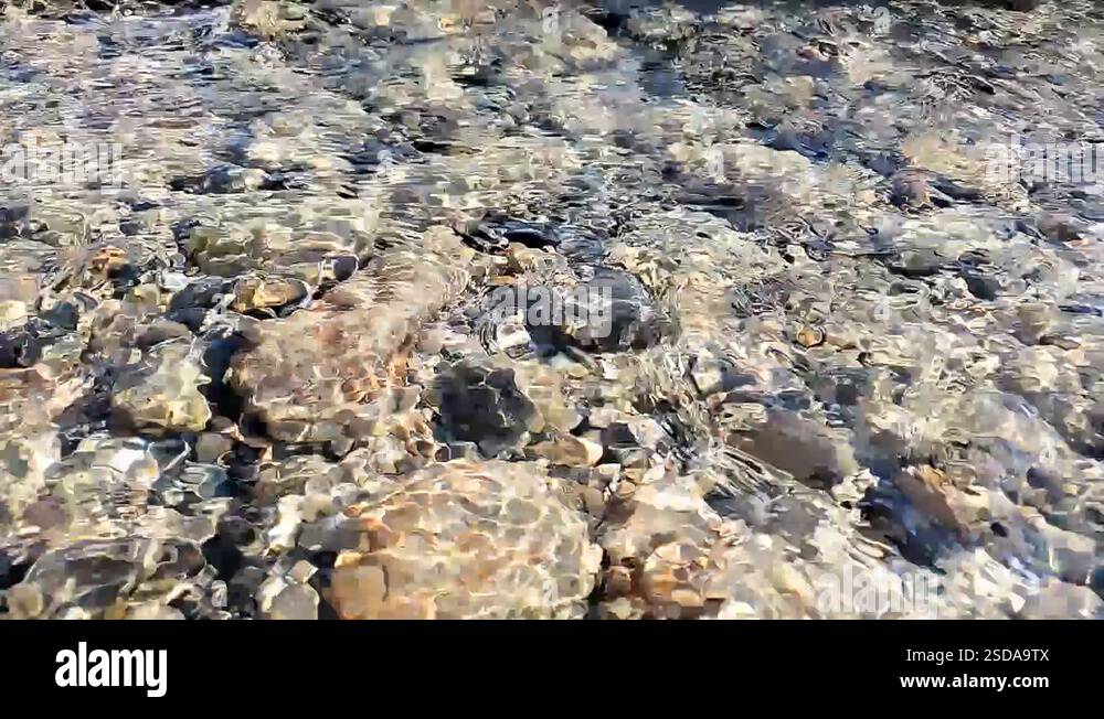 A gentle stream flowing over rocks in a Canadian river in British Stock ...