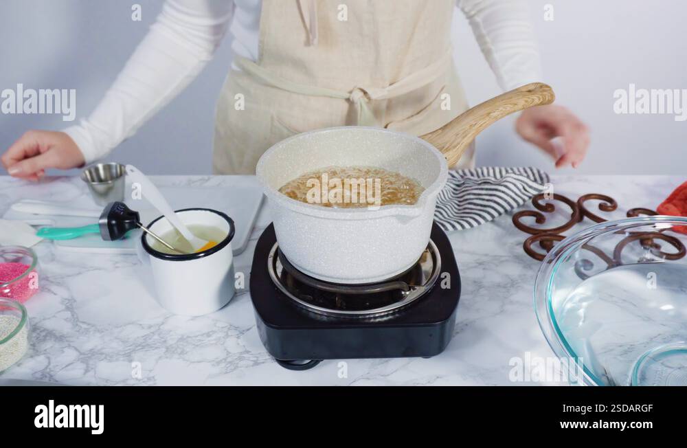 Caramelizing sugar in a small cooking pot over the small electric stove ...