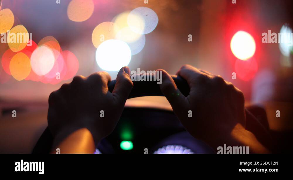 Commuter driver POV holding steering wheel waiting at red light in ...