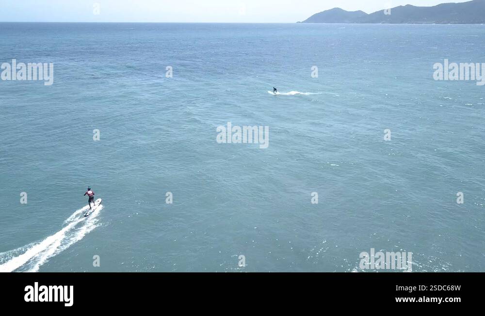 Aerial Orbit Shot about two Electric Surf Board riders, on the Coast of ...