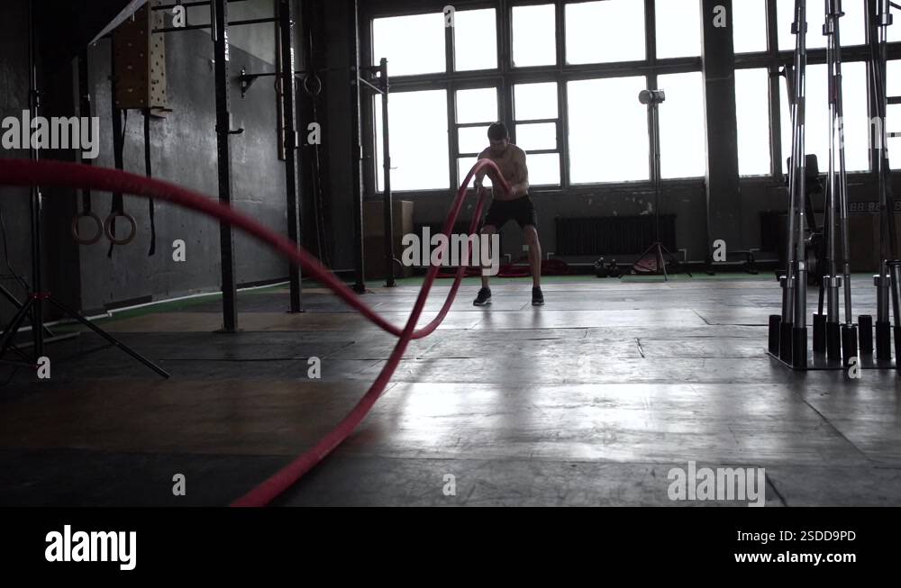 Strong young man training with battle ropes in crossfit gym Stock Video ...