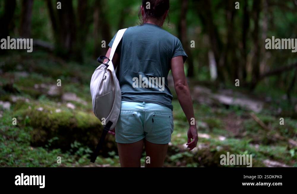 a woman in shorts and with a backpack on her shoulder climbs up the ...