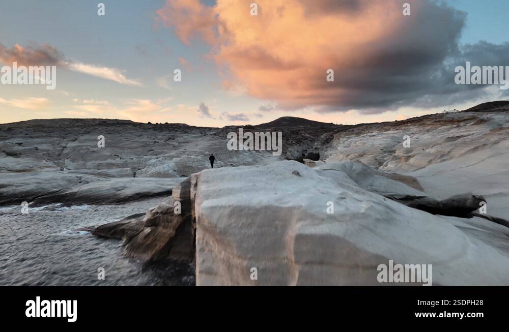 Aerial view flying over a man walking on white volcanic rocks in Stock ...