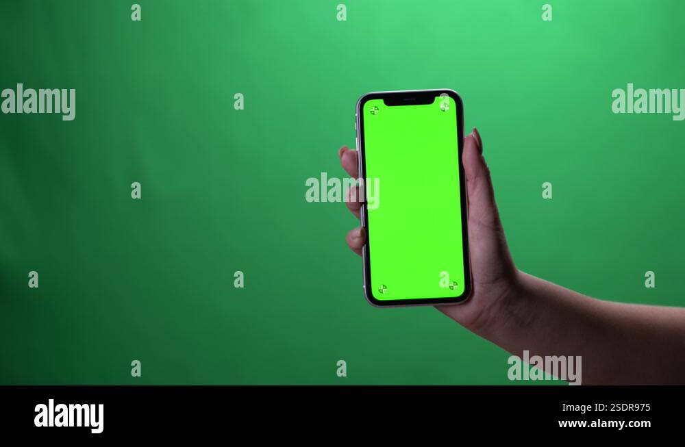 Woman hand holding the smartphone on green screen chroma key background ...