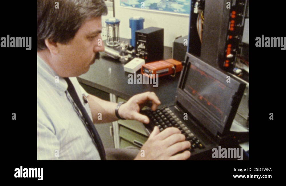1980s: Man sits at computer terminal in lab, types on keyboard. Graph ...