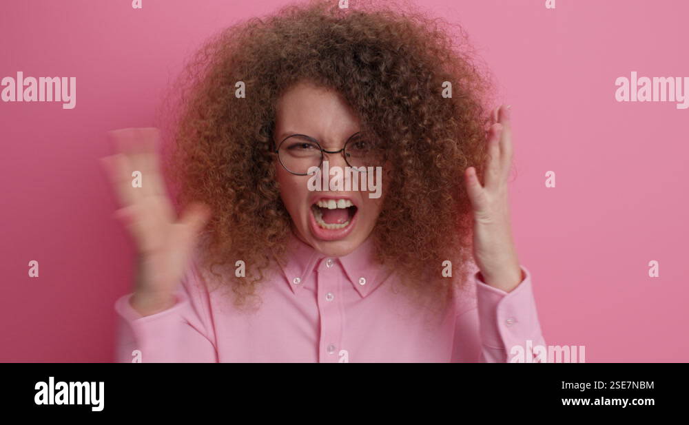 Outraged bothered woman shakes fists with rage stands furious complains ...