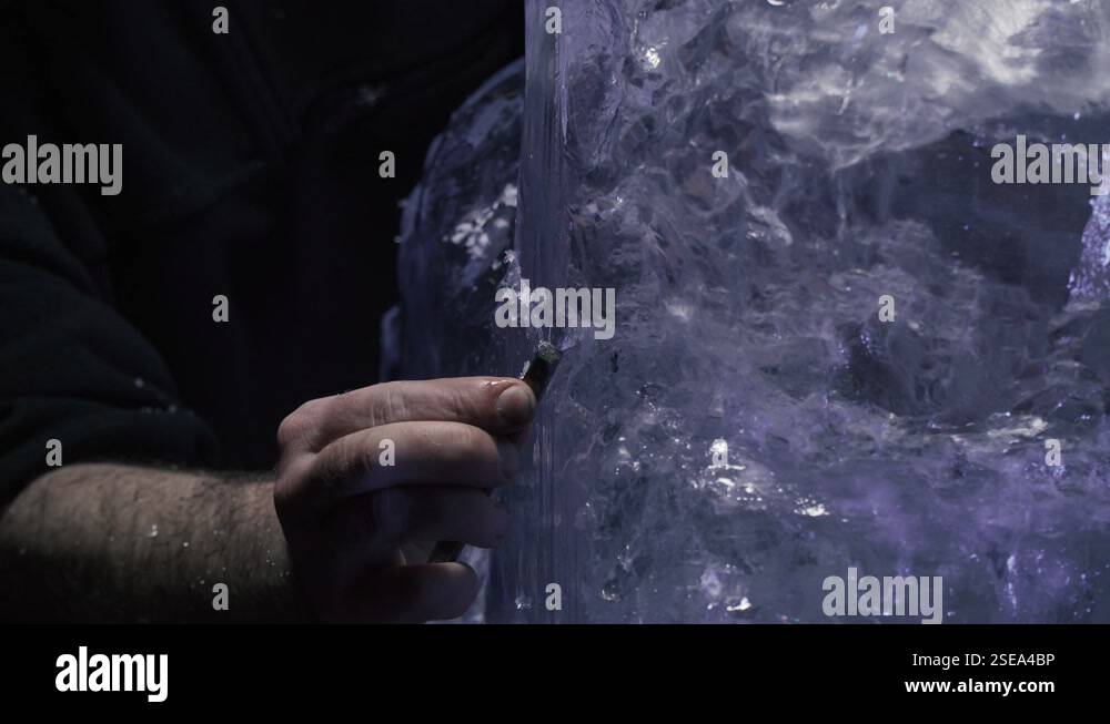 Shaping an ice sculpture using a chisel, professional artist at work ...