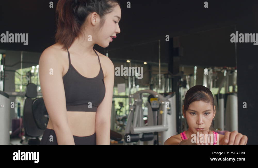 Asian lady trainer focus on body weight training squat with customer ...