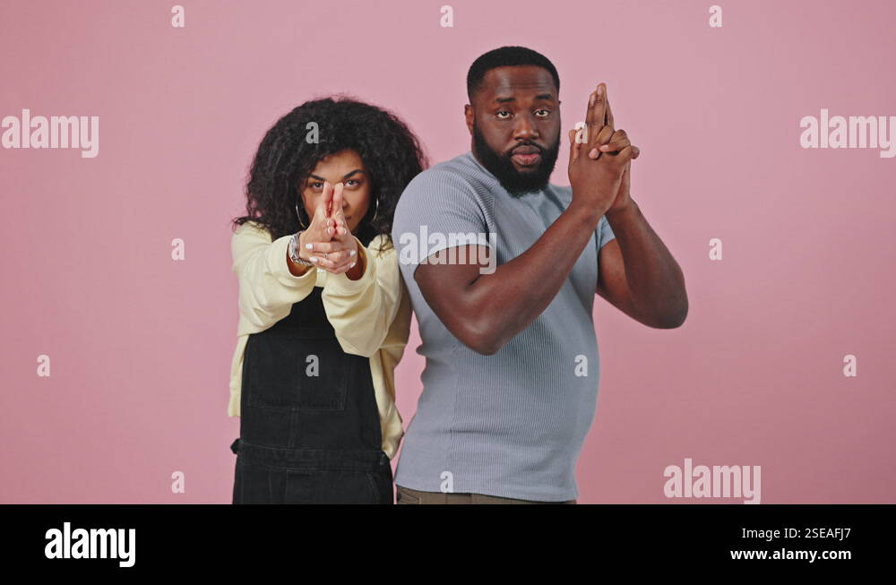 African american man and woman posing back to back, holding hands like ...