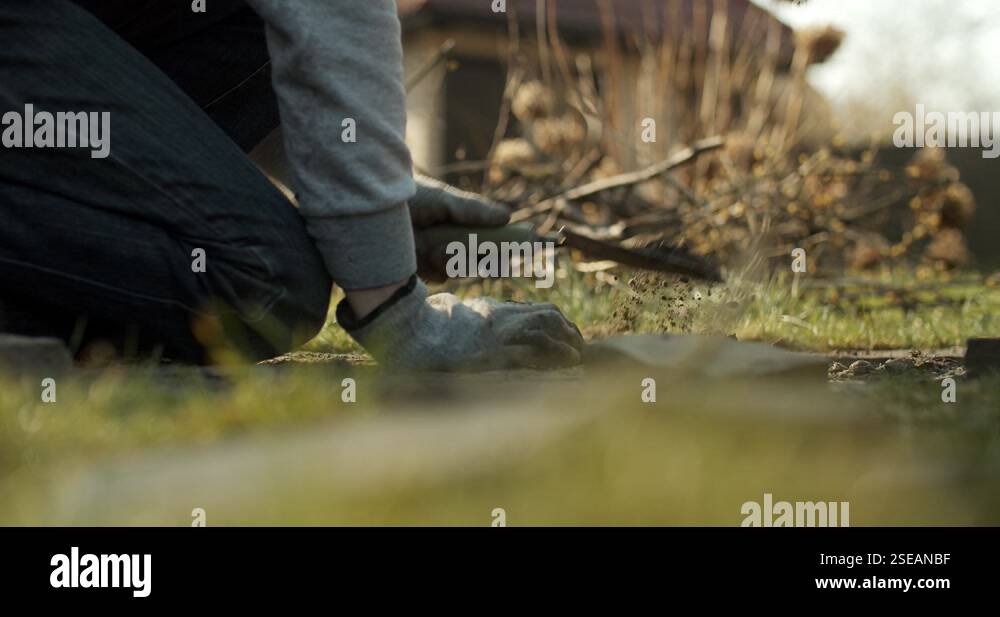 Man digging the ground to make a path from stones.Making backyard ...