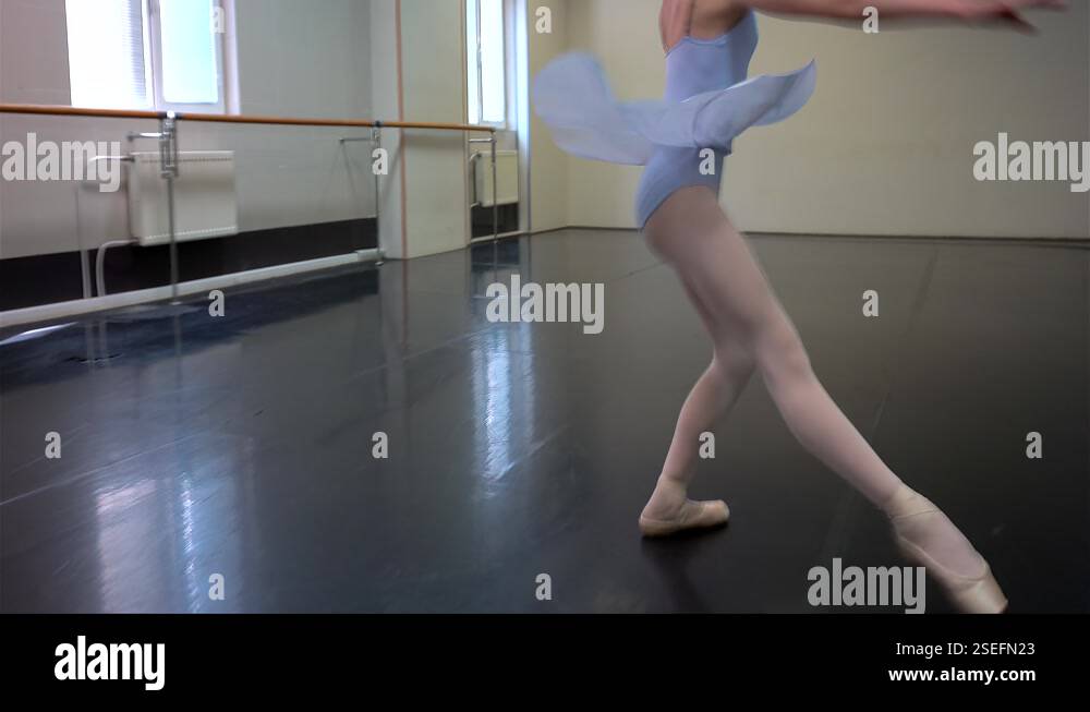 Young ballerina is performing a diagonal rotation in a ballet class ...